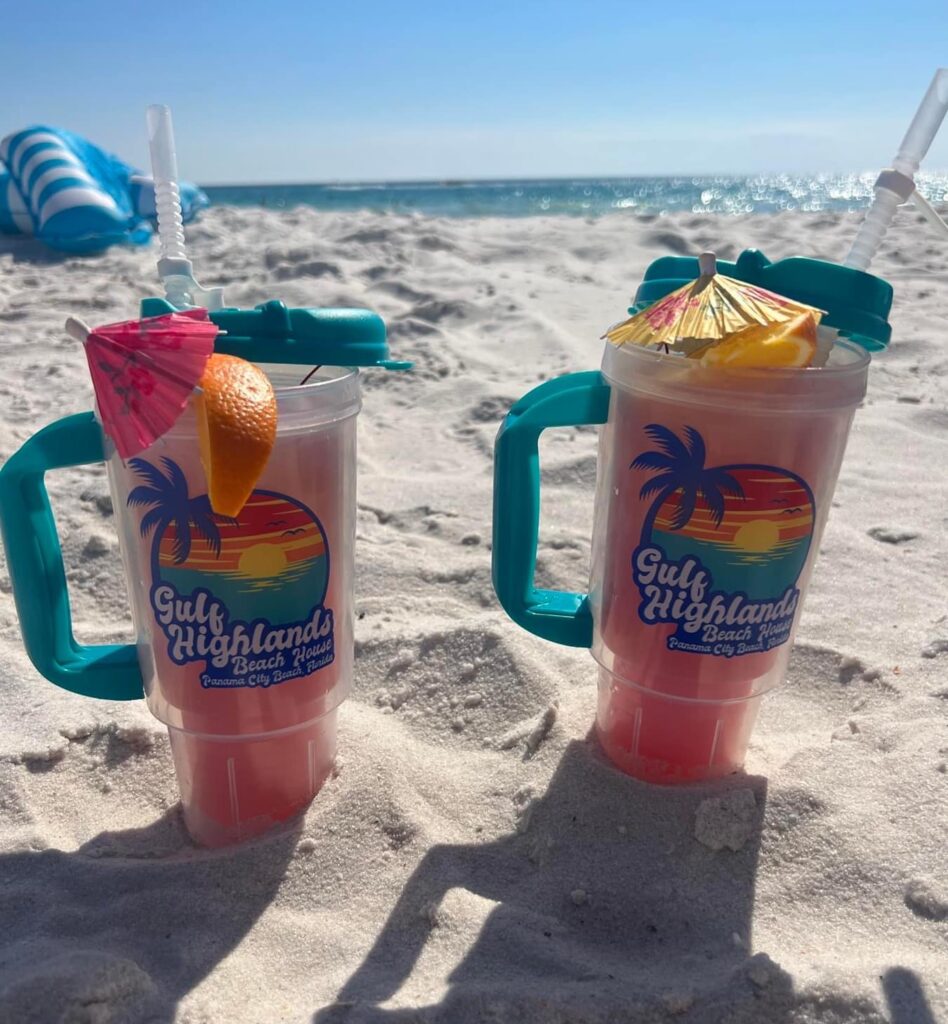 Frozen drinks in Gulf Highlands Beach House cups with colorful umbrellas on the beach